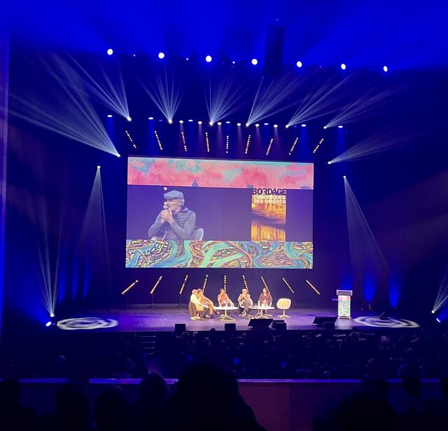 Ugo Bellagamba, Ayavi Lake, Pierre Bordage (projeté à l'écran) et Floriane Soulas sur la grande scène des Utopiales 2023.