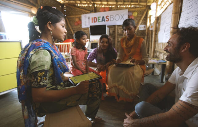 Augustin Trapenard auprès de femmes rohingyas, au Bangladesh, pour Bibliothèques Sans Frontières.