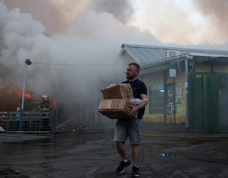 Un homme transporte des cartons contenant des objets récupérés sur le marché aux livres ravagé par un incendie