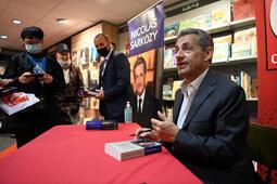 Nicolas Sarkozy lors d'une séane de dédicace en octobre 2021. (Photo by CHRISTOPHE SIMON / AFP)